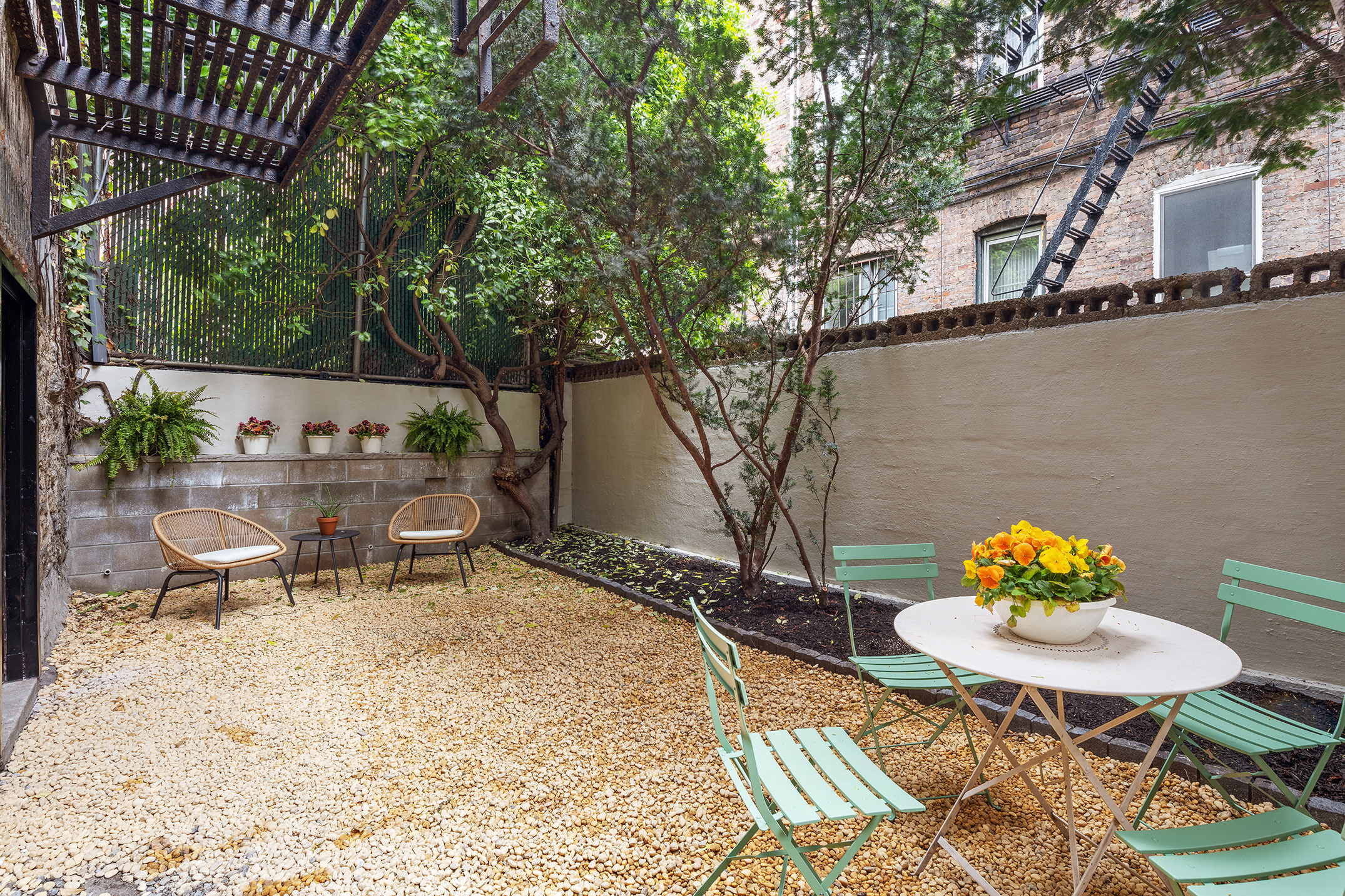 71 East 3rd Street, Unit 4 Manhattan, NY 10003 - Photo 13 of 18 a backyard of a house with table and chairs