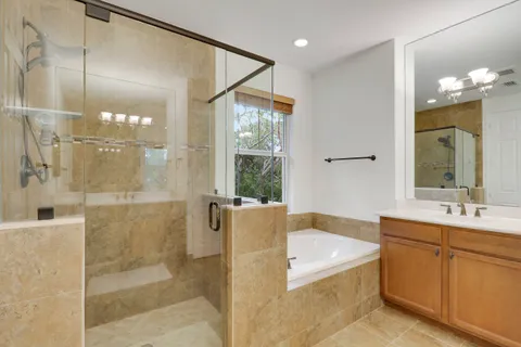 a bathroom with a tub sink shower and mirror