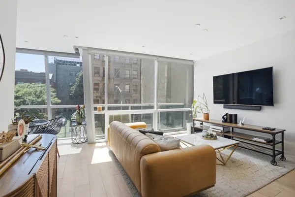 a living room with furniture a flat screen tv and a large window