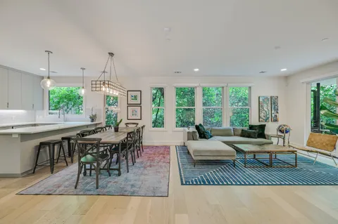 a living room with furniture a large window and a table