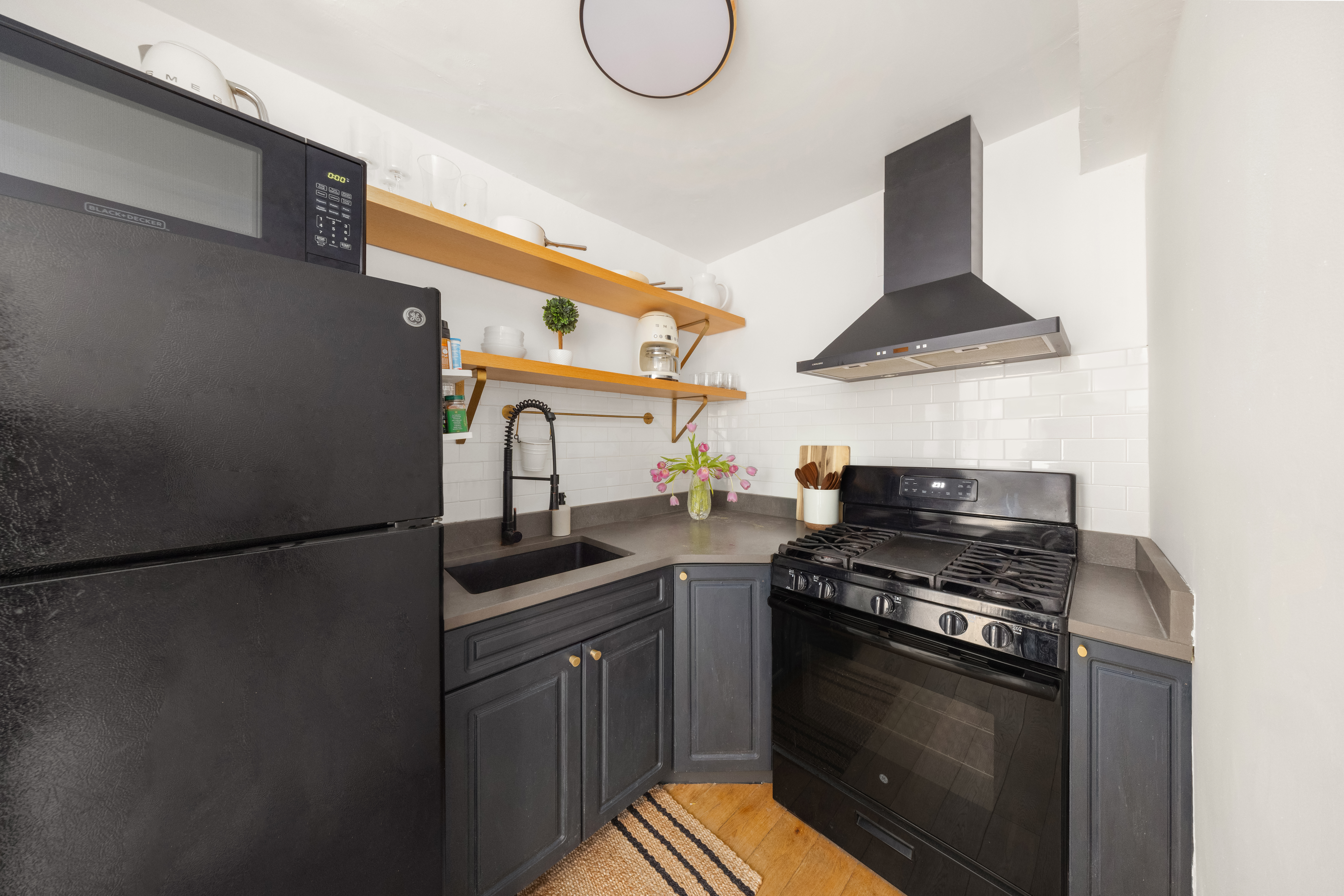 150 East 61st Street, Unit 2A Manhattan, NY 10065 - Photo 7 of 9 a kitchen with stainless steel appliances a stove a sink and a refrigerator