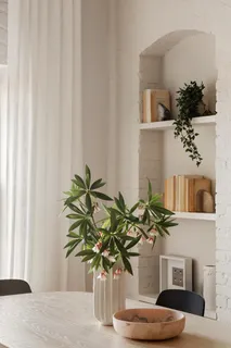 a vase of flowers sitting on a table with window