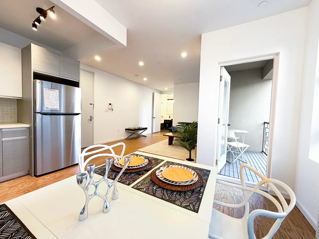 a room with furniture a flat screen tv and kitchen view