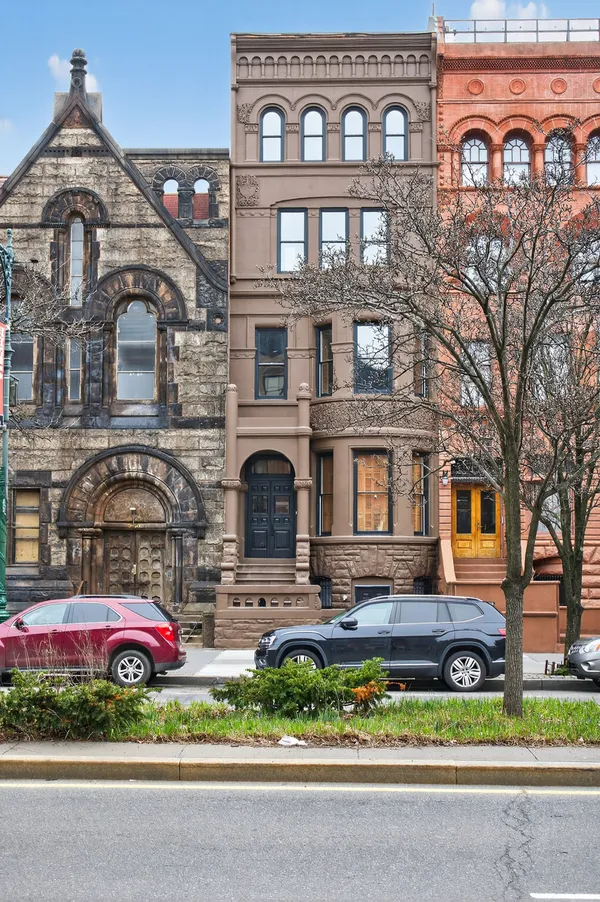a front view of a house with a garden and parking