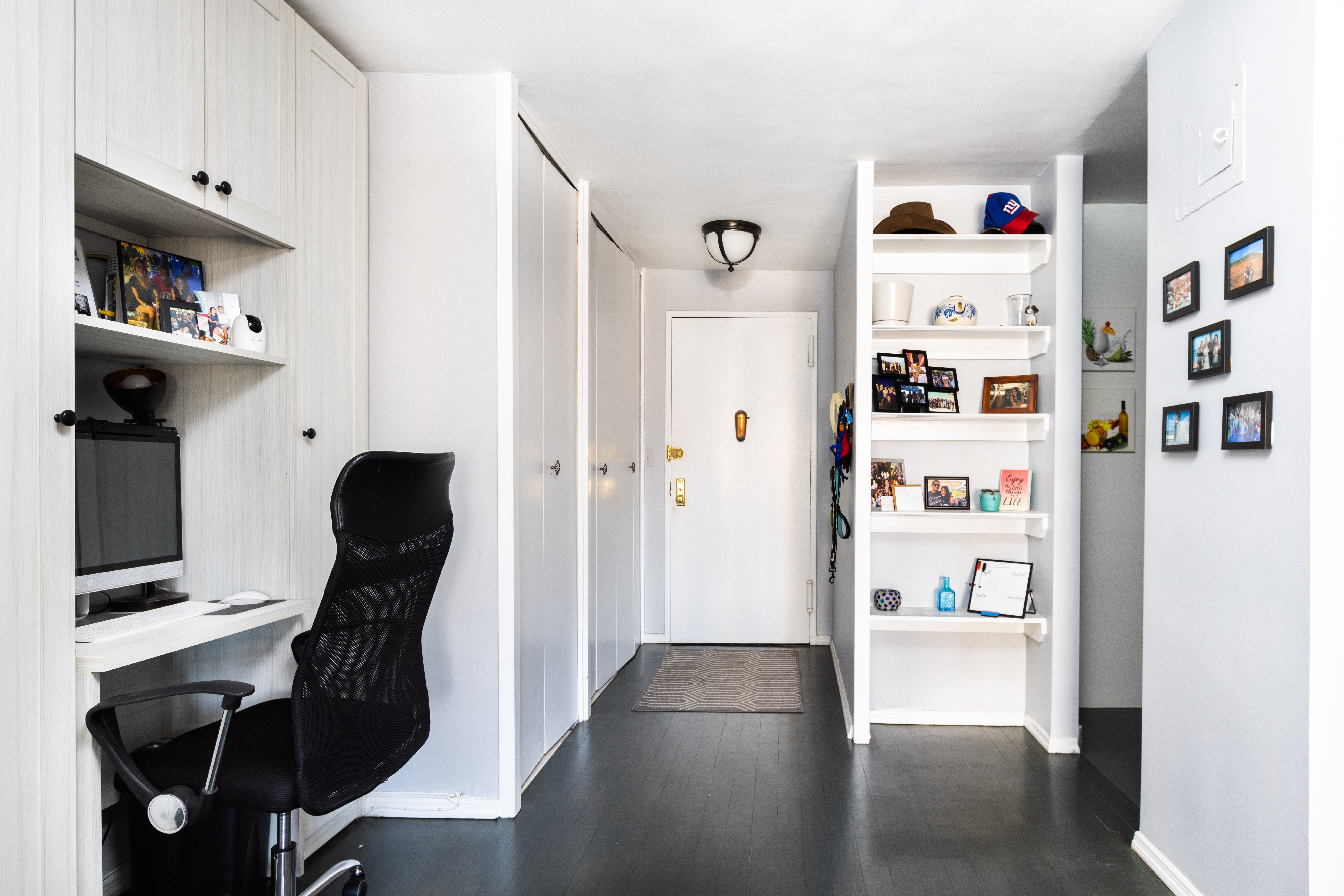 245 East 25th Street, Unit 19L Manhattan, NY 10010 - Photo 5 of 13 a view of a hallway with shelves and wooden floor