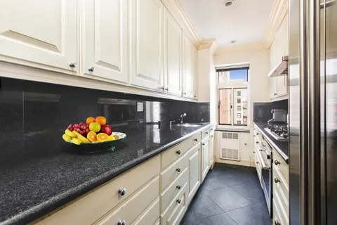 a kitchen with stainless steel appliances white cabinets and a sink