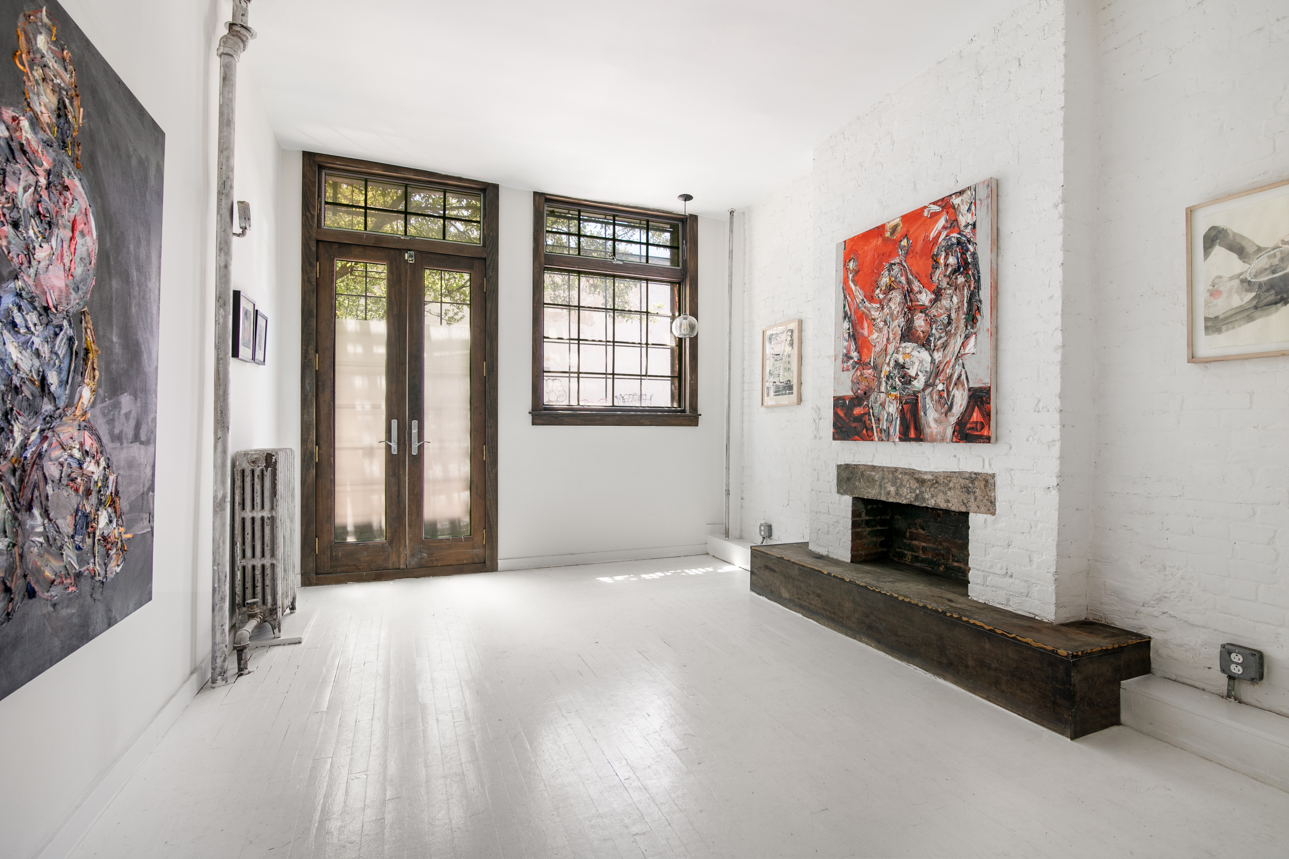 305 East 4th Street, Unit GARDEN Manhattan, NY 10009 - Photo 2 of 8 a view of an empty room with a fireplace and a window