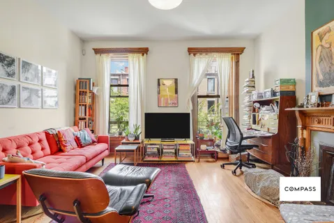 a living room with furniture a flat screen tv and a window