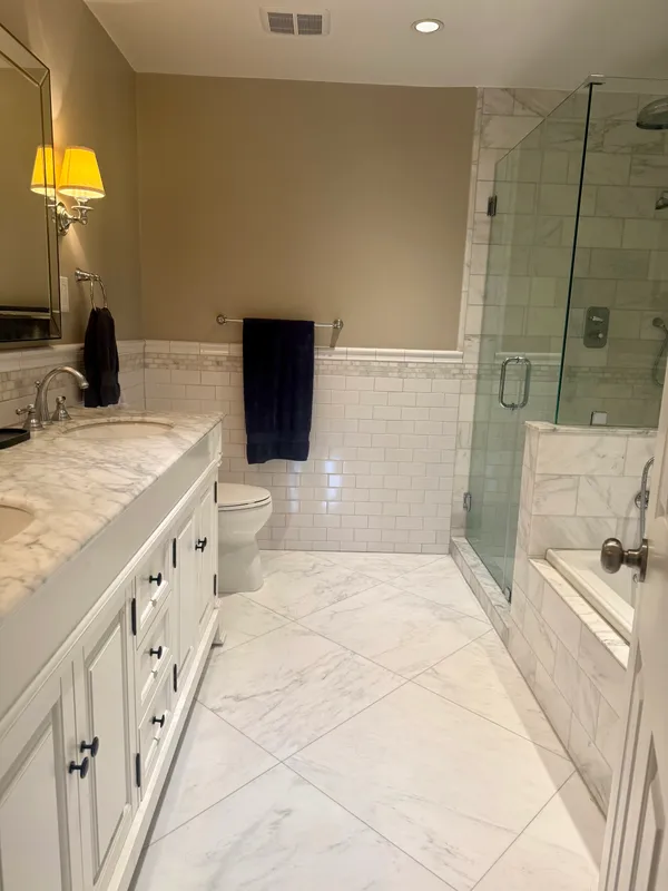 a bathroom with a double vanity sink a toilet and a tub