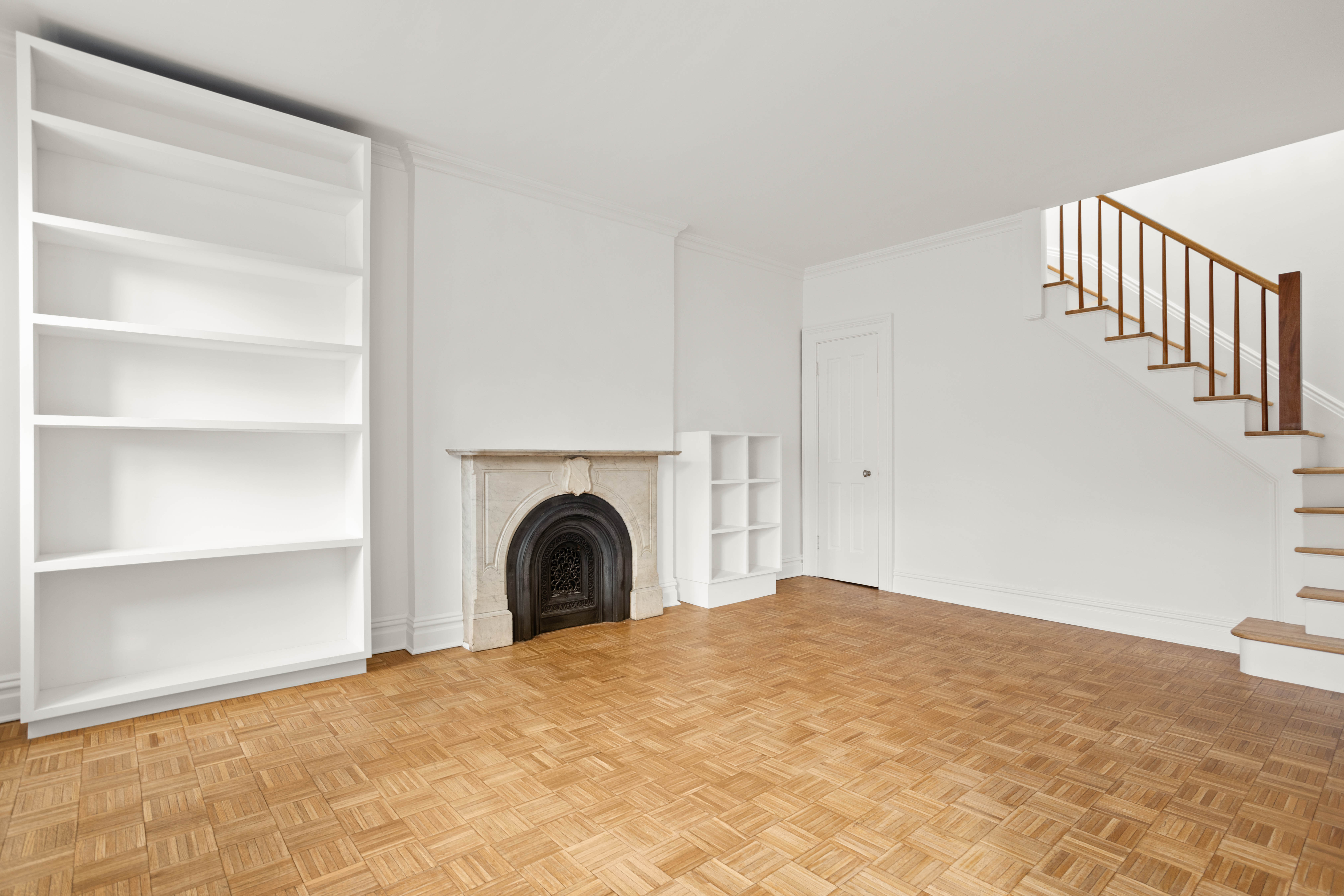 357 West 20th Street, Unit B Manhattan, NY 10011 - Photo 3 of 10 a view of an empty room with stairs and a fireplace