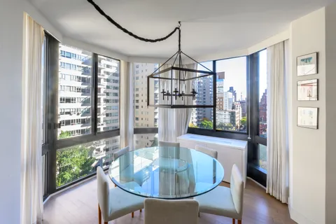 a dining room with furniture a chandelier and wooden floor