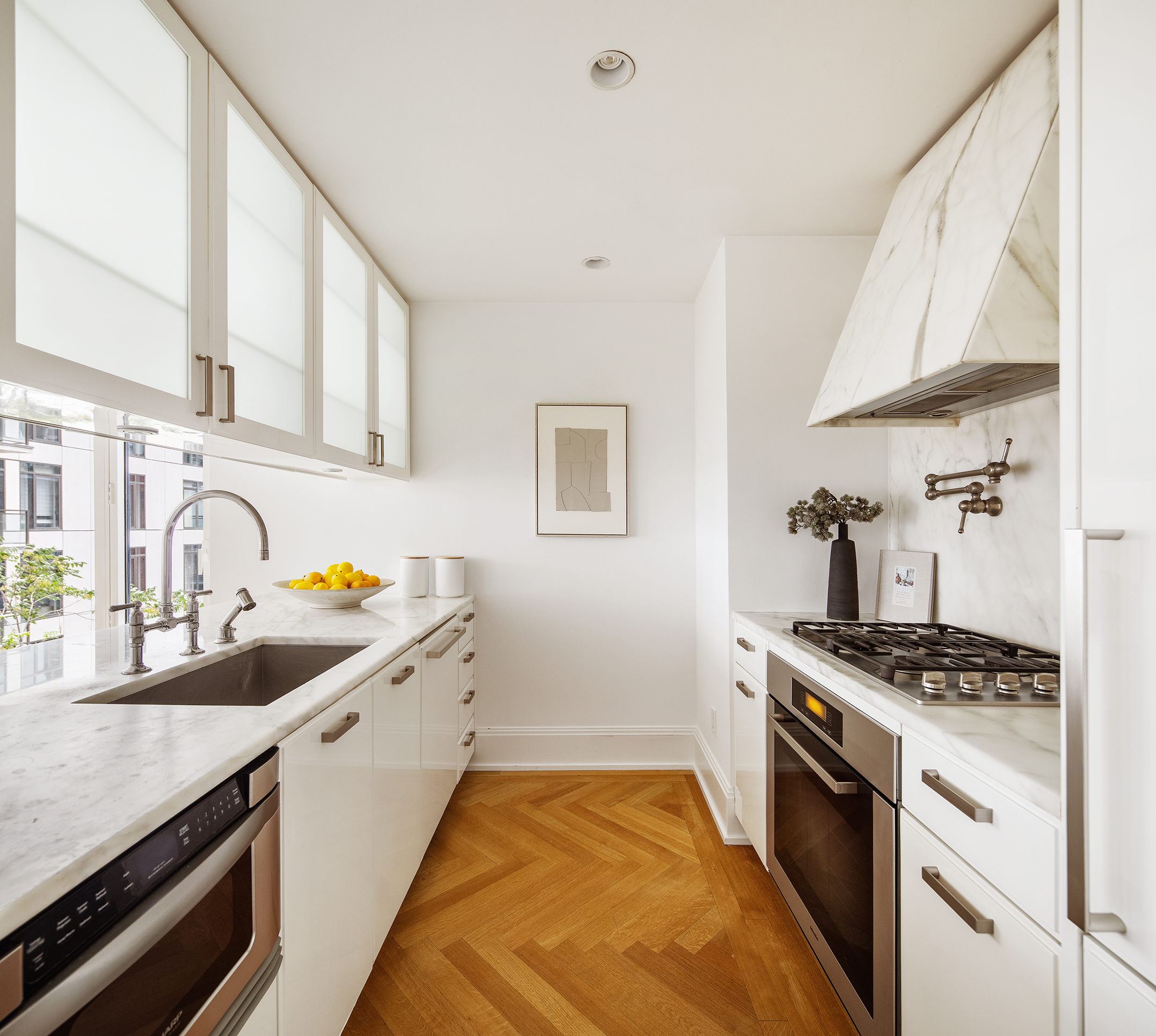 305 East 85th Street, Unit 5B Manhattan, NY 10028 - Photo 5 of 11 a kitchen with granite countertop a sink stove and cabinets