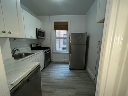 a kitchen with a refrigerator sink and cabinets