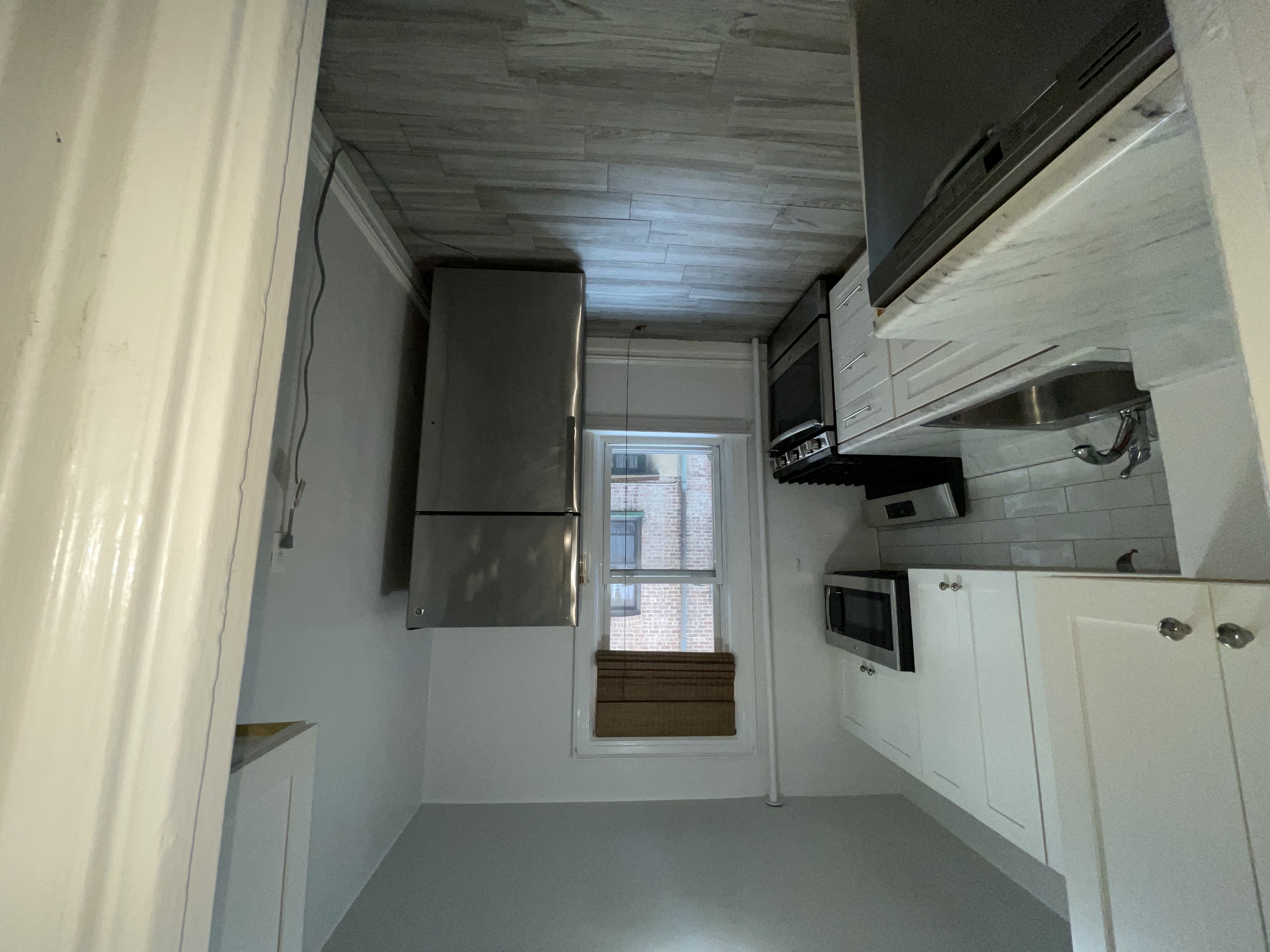 31-74 33rd Street Queens, NY 11106 - Photo 8 of 16 a kitchen with a refrigerator sink and cabinets
