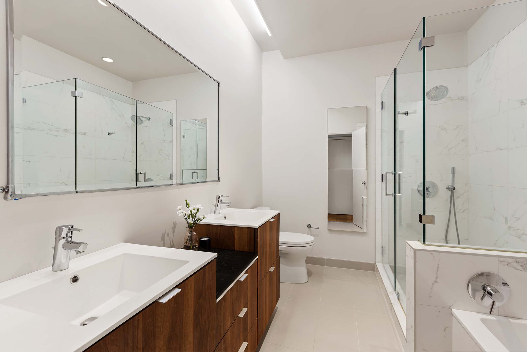 27 Clermont Avenue Brooklyn, NY 11205 - Photo 11 of 19 a bathroom with a double vanity sink a toilet and a tub