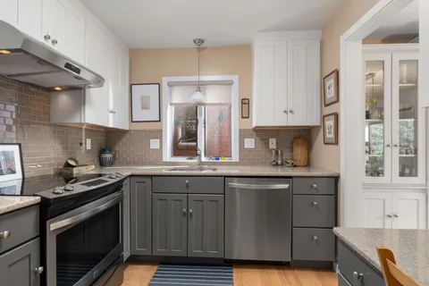 a kitchen with stainless steel appliances granite countertop a sink stove and cabinets
