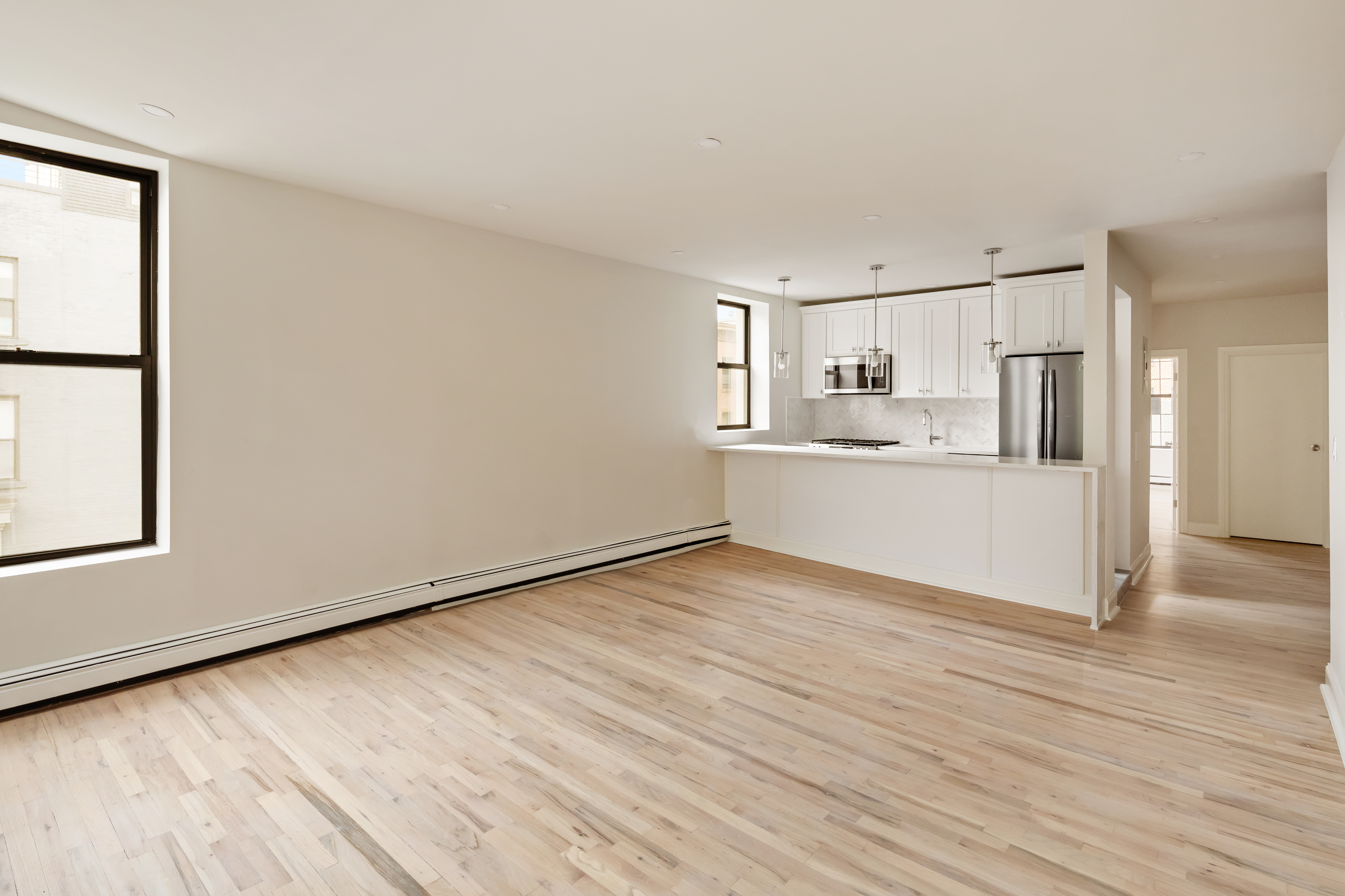 a view of a kitchen with wooden floor and electronic appliances