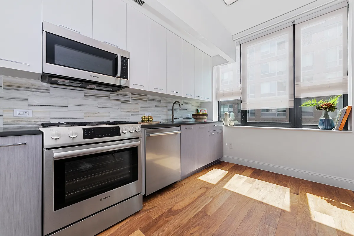 42-14 Crescent Street, Unit 9D Queens, NY 11101 - Photo 3 of 6 a kitchen with stainless steel appliances a stove microwave and sink