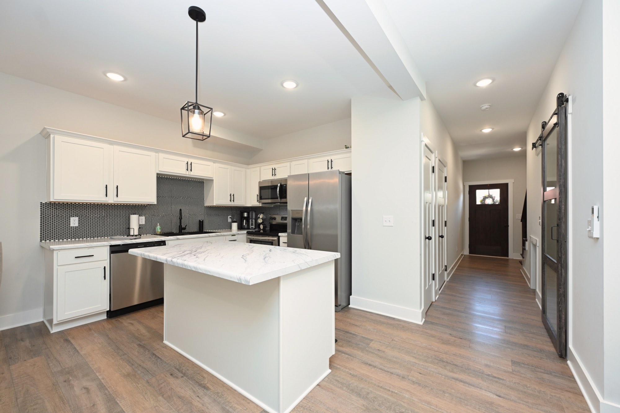 211 Golf Club Lane Springfield, TN 37172 - Photo 18 of 41 a kitchen with stainless steel appliances kitchen island a refrigerator a sink dishwasher a stove and white cabinets with wooden floor