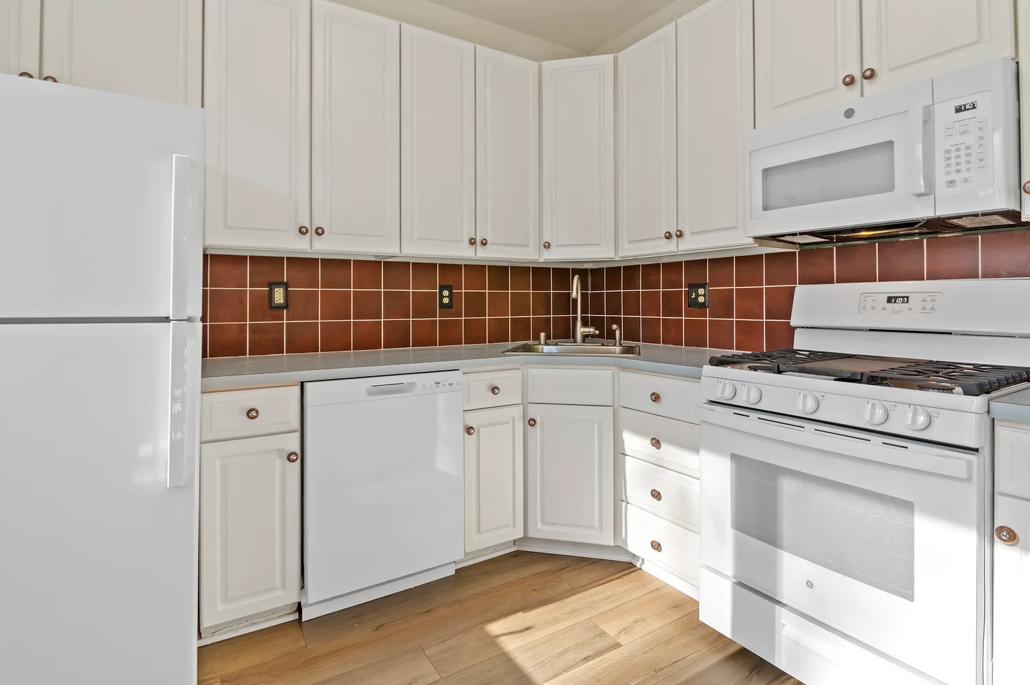 a kitchen with granite countertop white cabinets and white appliances