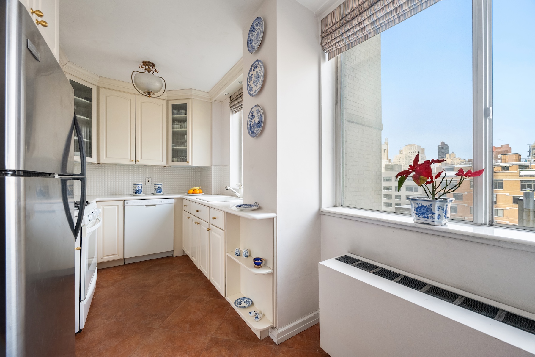 515 East 79th Street, Unit 15A Manhattan, NY 10075 - Photo 6 of 26 a kitchen with white cabinets and white appliances