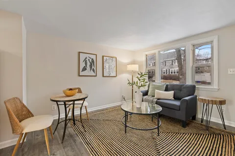 a living room with furniture a rug and a window
