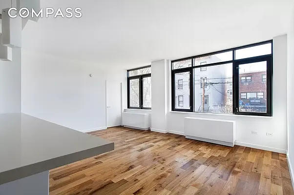125 North 5th Street, Unit 2E Brooklyn, NY 11249 - Photo 1 of 11 an empty room with wooden floor and windows
