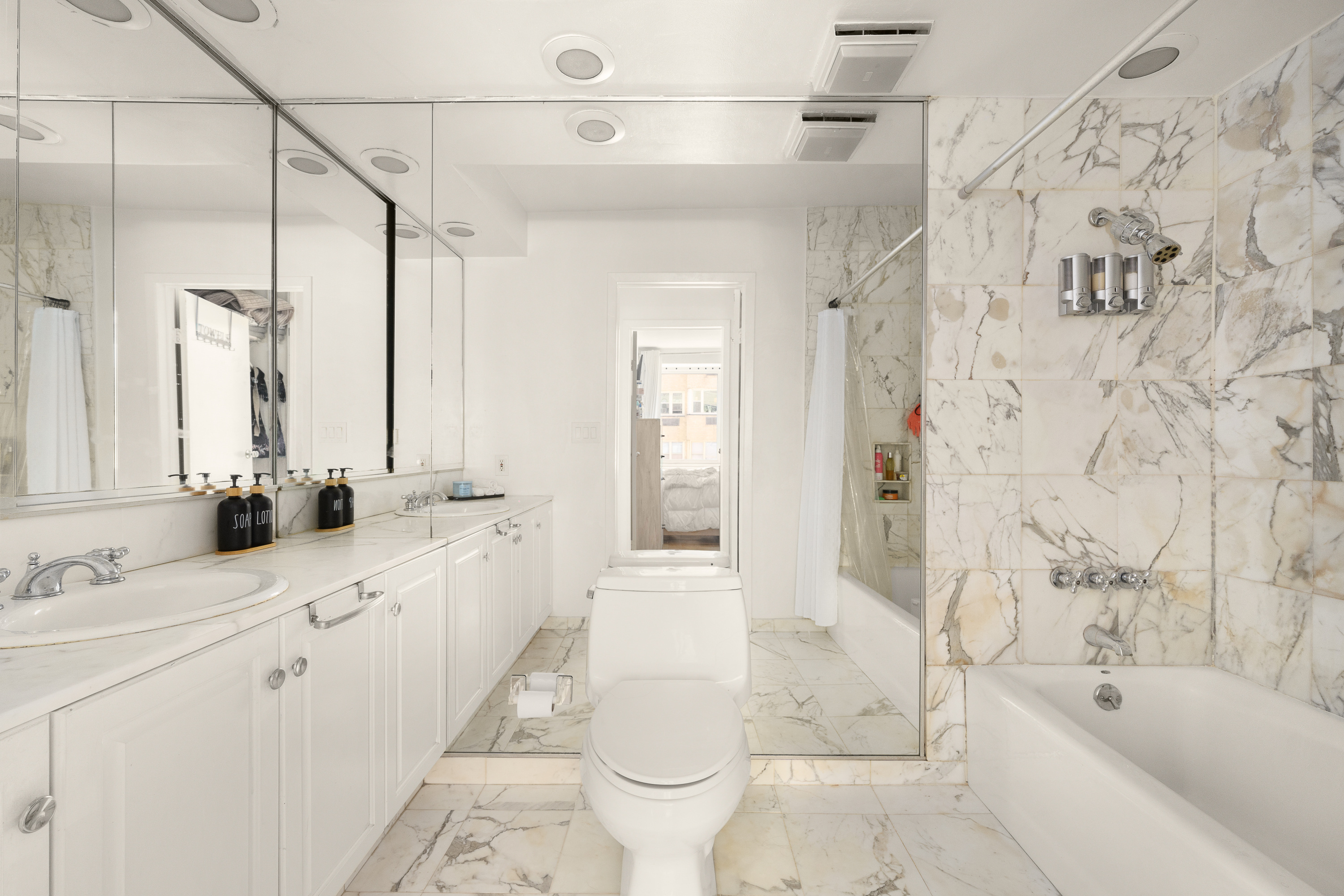 411 East 53rd Street, Unit 10E Manhattan, NY 10022 - Photo 6 of 8 a bathroom with a double vanity sink toilet and shower