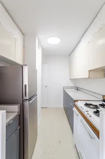 a kitchen with stainless steel appliances granite countertop a refrigerator and a stove