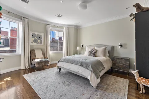 a bedroom with a large bed and wooden floor