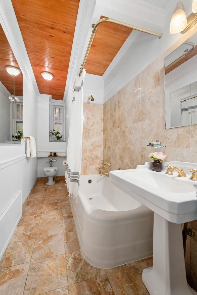 a bathroom with a tub sink and mirror