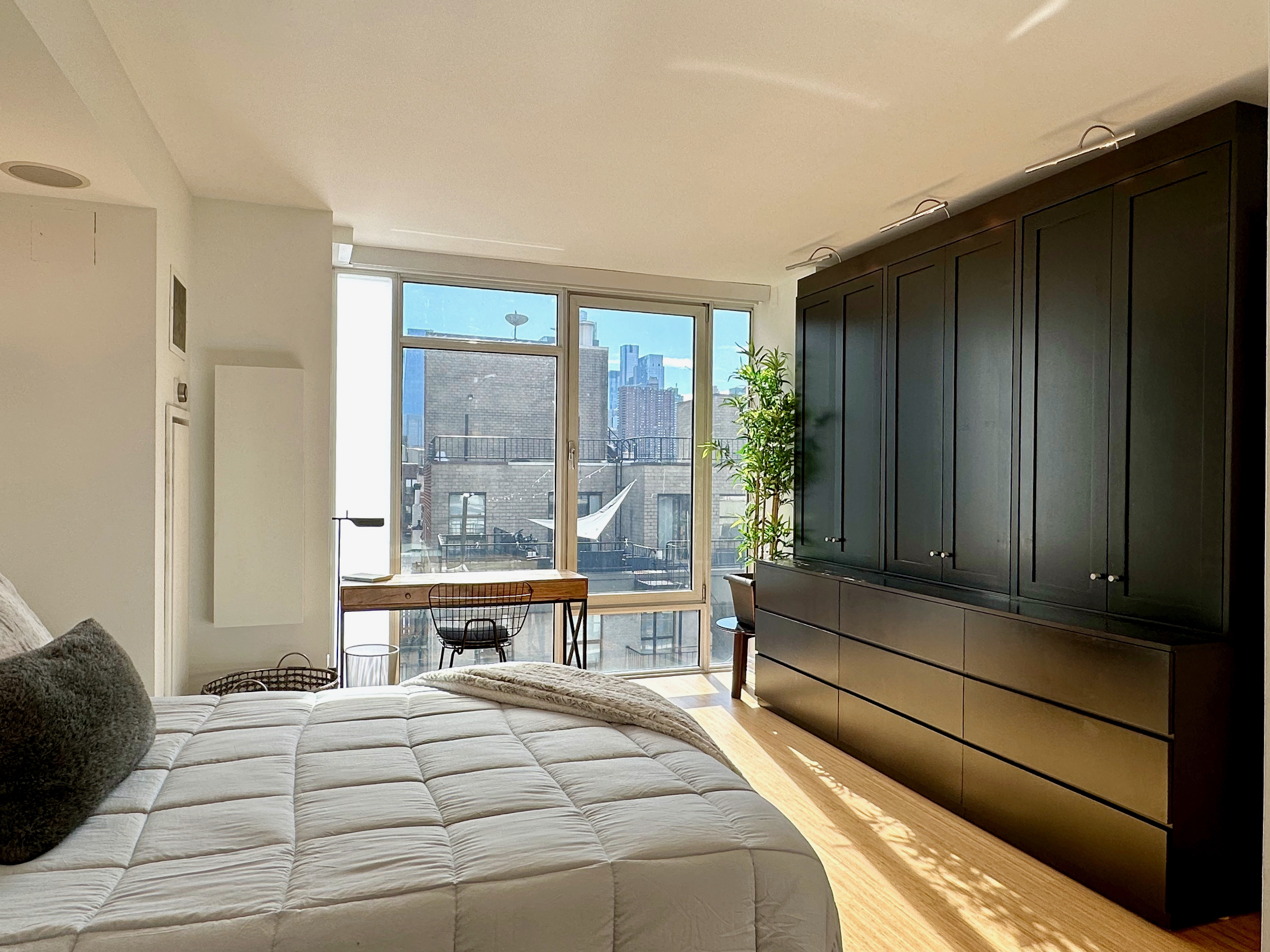350 West 53rd Street, Unit PHA Manhattan, NY 10019 - Photo 11 of 35 a bedroom with a bed and large window