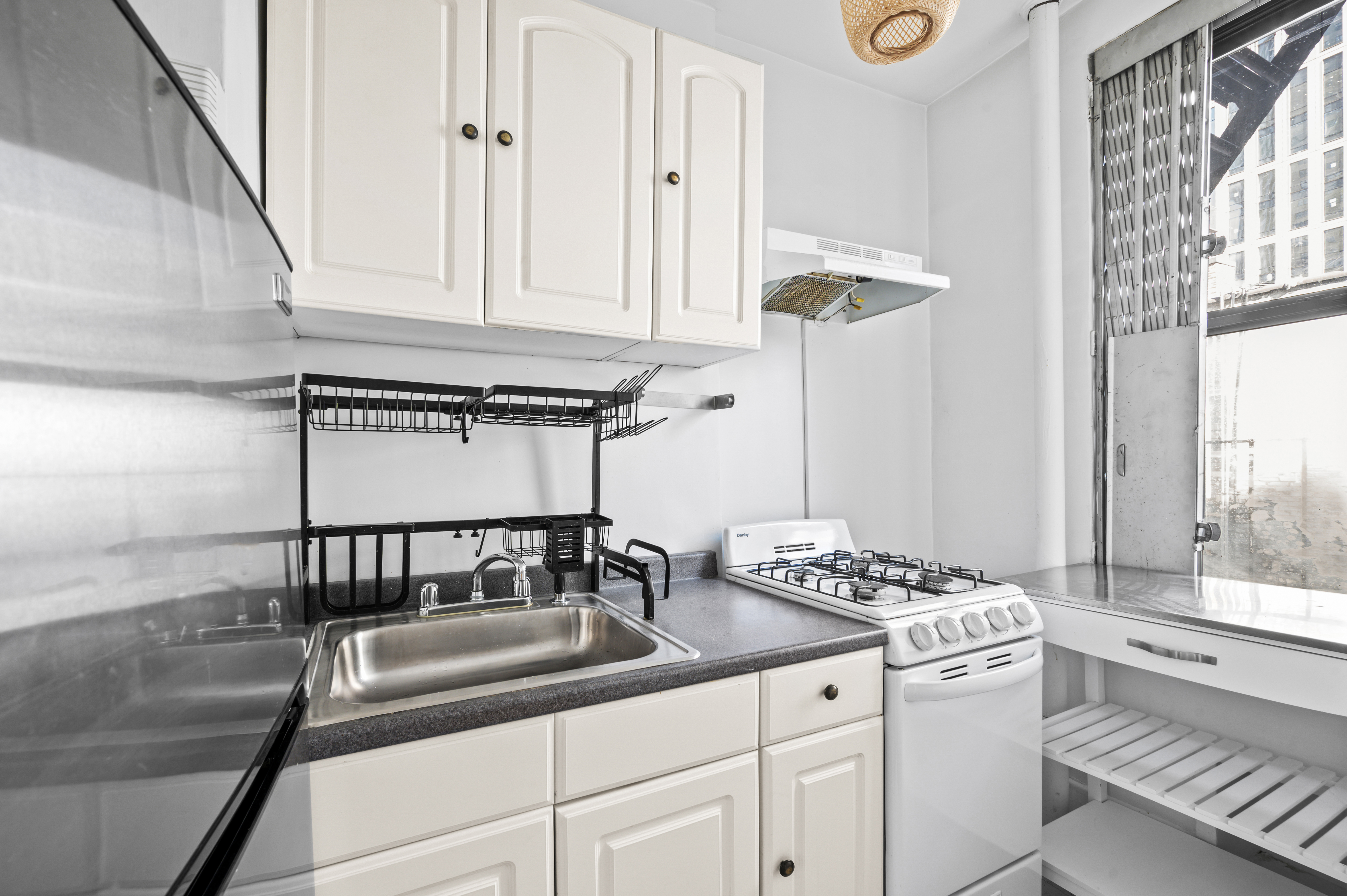 17 West 64th Street, Unit 6E Manhattan, NY 10023 - Photo 4 of 6 a kitchen with a sink and cabinets