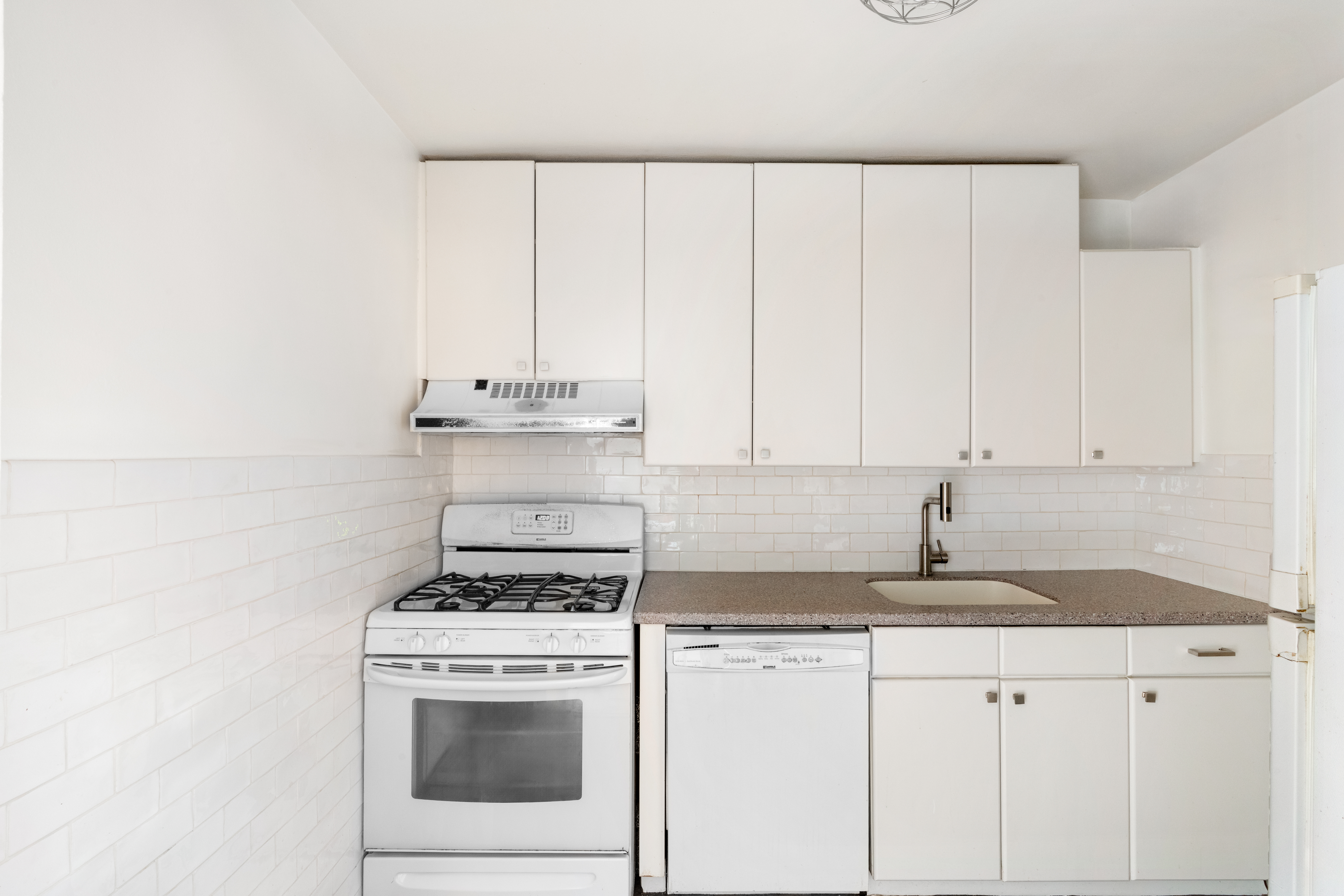 315 East 70th Street, Unit 6K Manhattan, NY 10021 - Photo 7 of 7 a kitchen with granite countertop white cabinets and white appliances