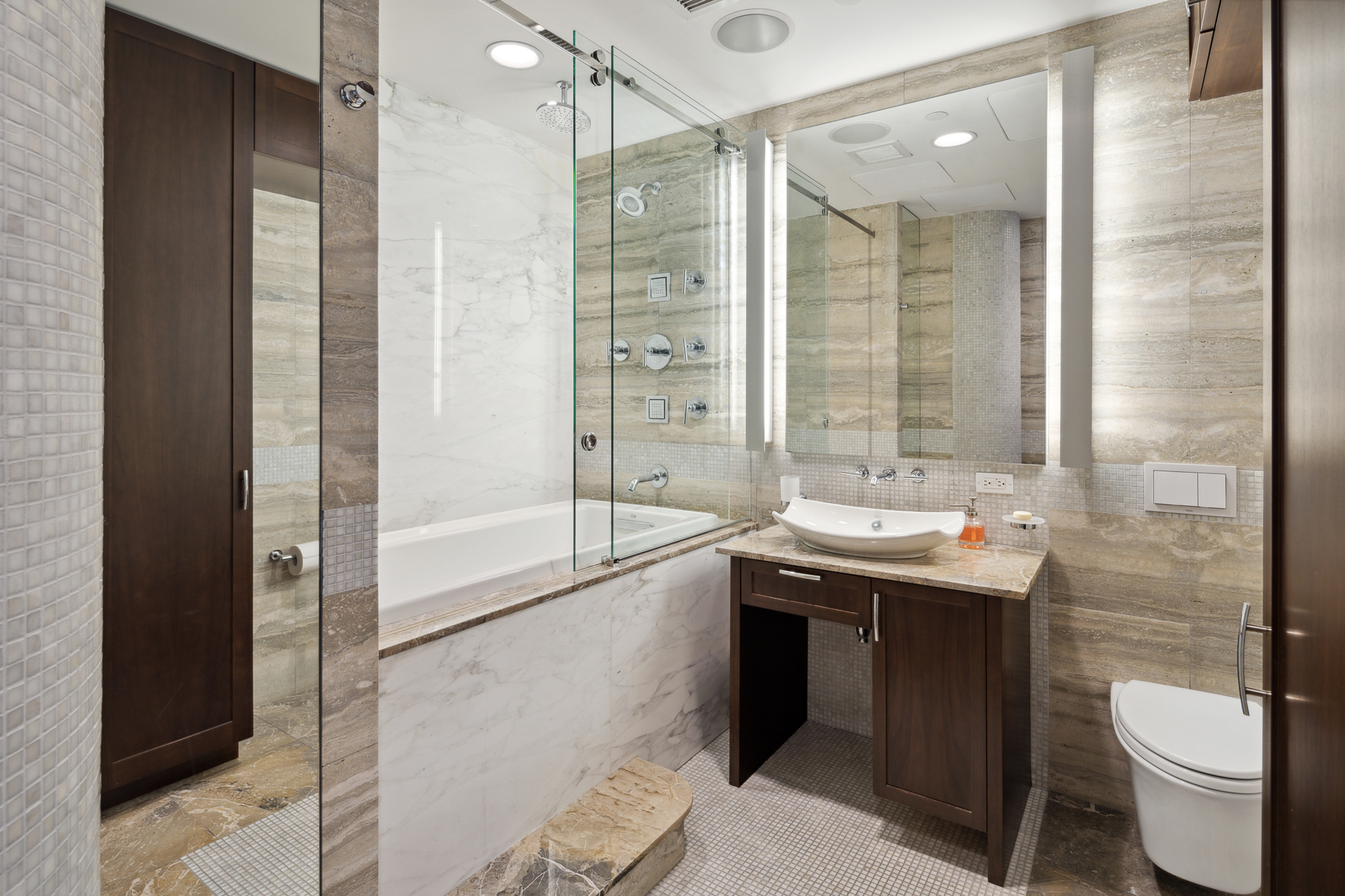 561 Broadway, Unit 10C Manhattan, NY 10012 - Photo 10 of 11 a bathroom with a granite countertop sink toilet and shower