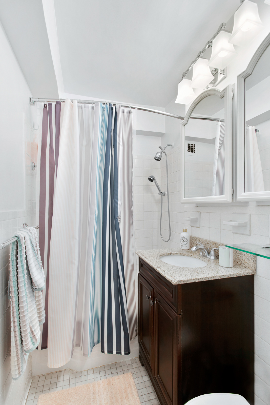 335 East 51st Street, Unit 10C Manhattan, NY 10022 - Photo 5 of 9 a bathroom with a sink vanity and a mirror