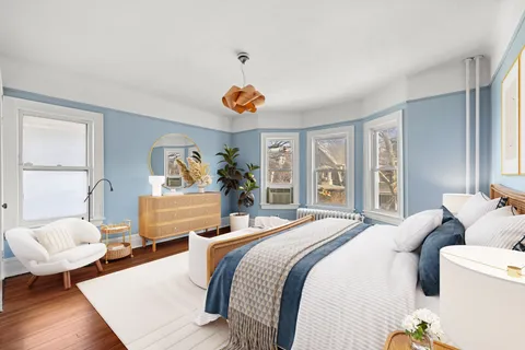 a bedroom with a bed and wooden floor