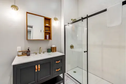 a bathroom with a double vanity sink mirror and shower