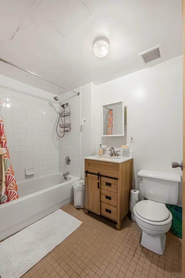 a spacious bathroom with a granite countertop toilet a sink and a bathtub