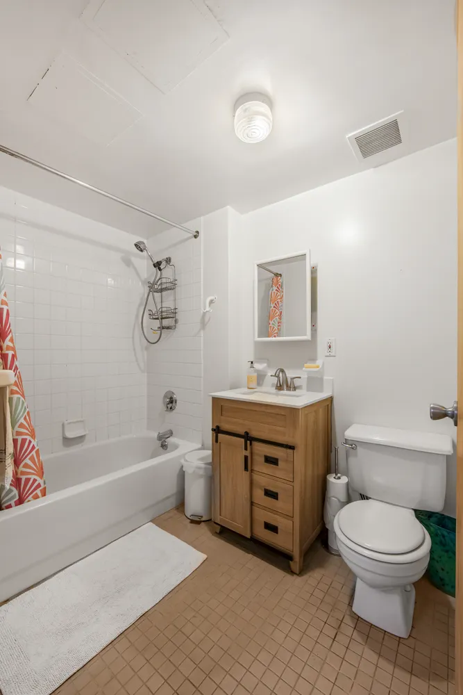 a spacious bathroom with a granite countertop toilet a sink and a bathtub