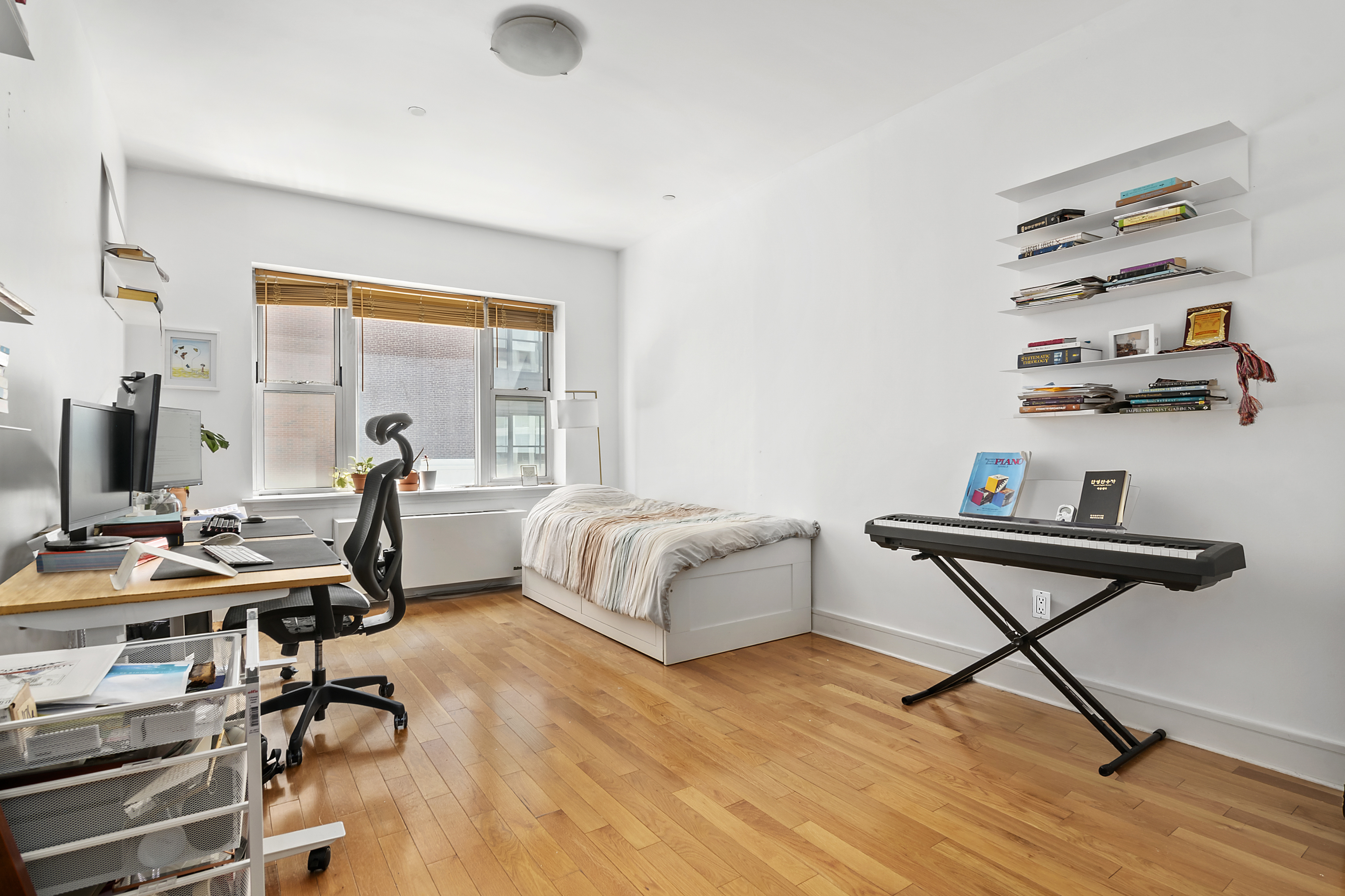 41-26 27th Street, Unit 4H Queens, NY 11101 - Photo 5 of 21 a bedroom with furniture and a wooden floor