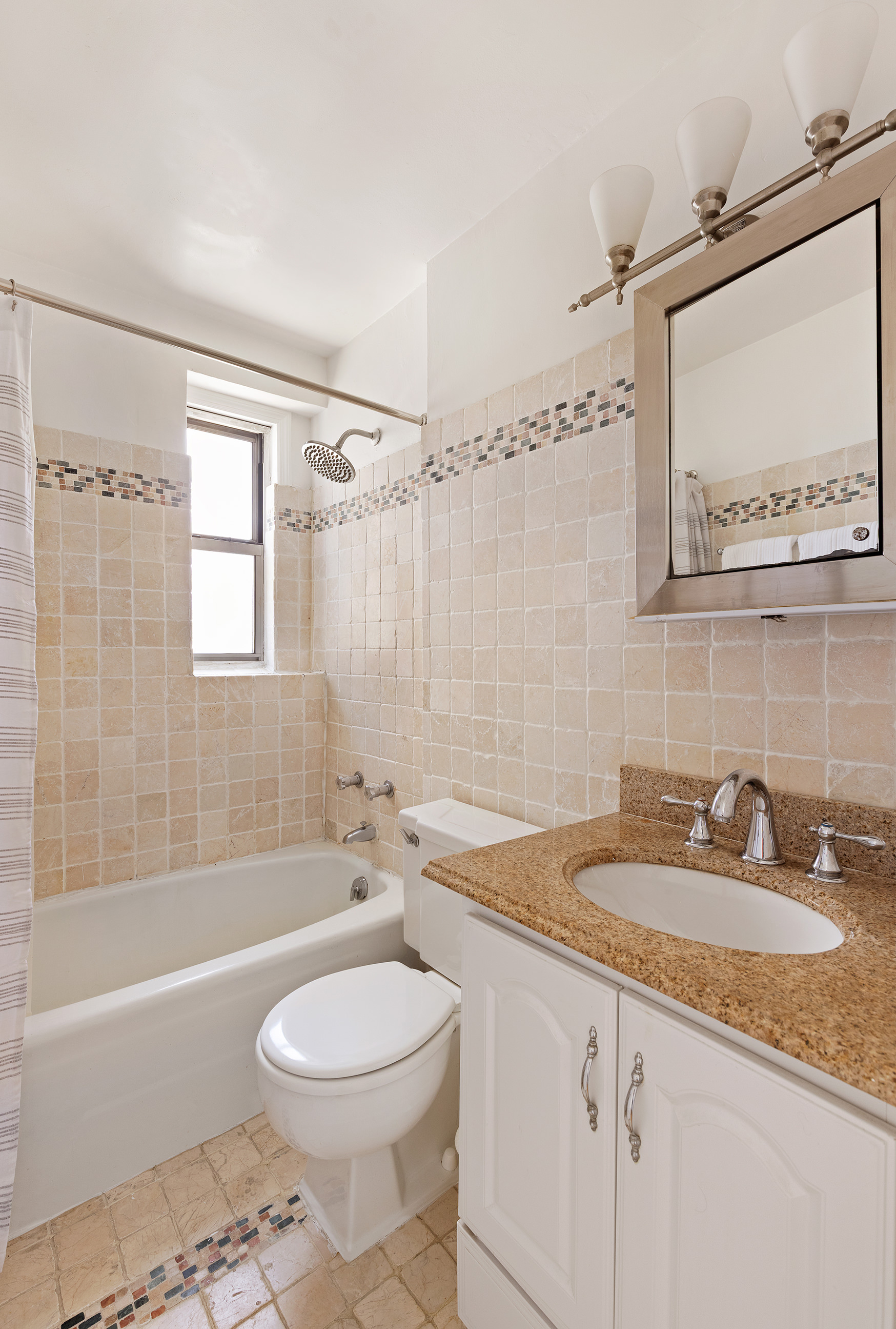 525 East 82nd Street, Unit 12E Manhattan, NY 10028 - Photo 22 of 29 a bathroom with a granite countertop sink a toilet a mirror a bathtub and shower