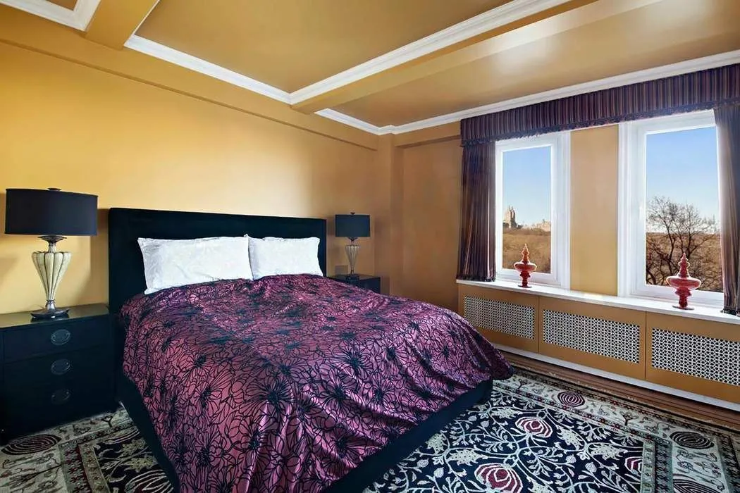 a bed sitting in a bedroom next to a window