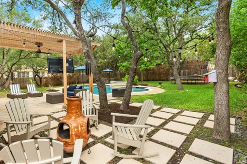 a view of a patio with a dining table and chairs with wooden floor and fence