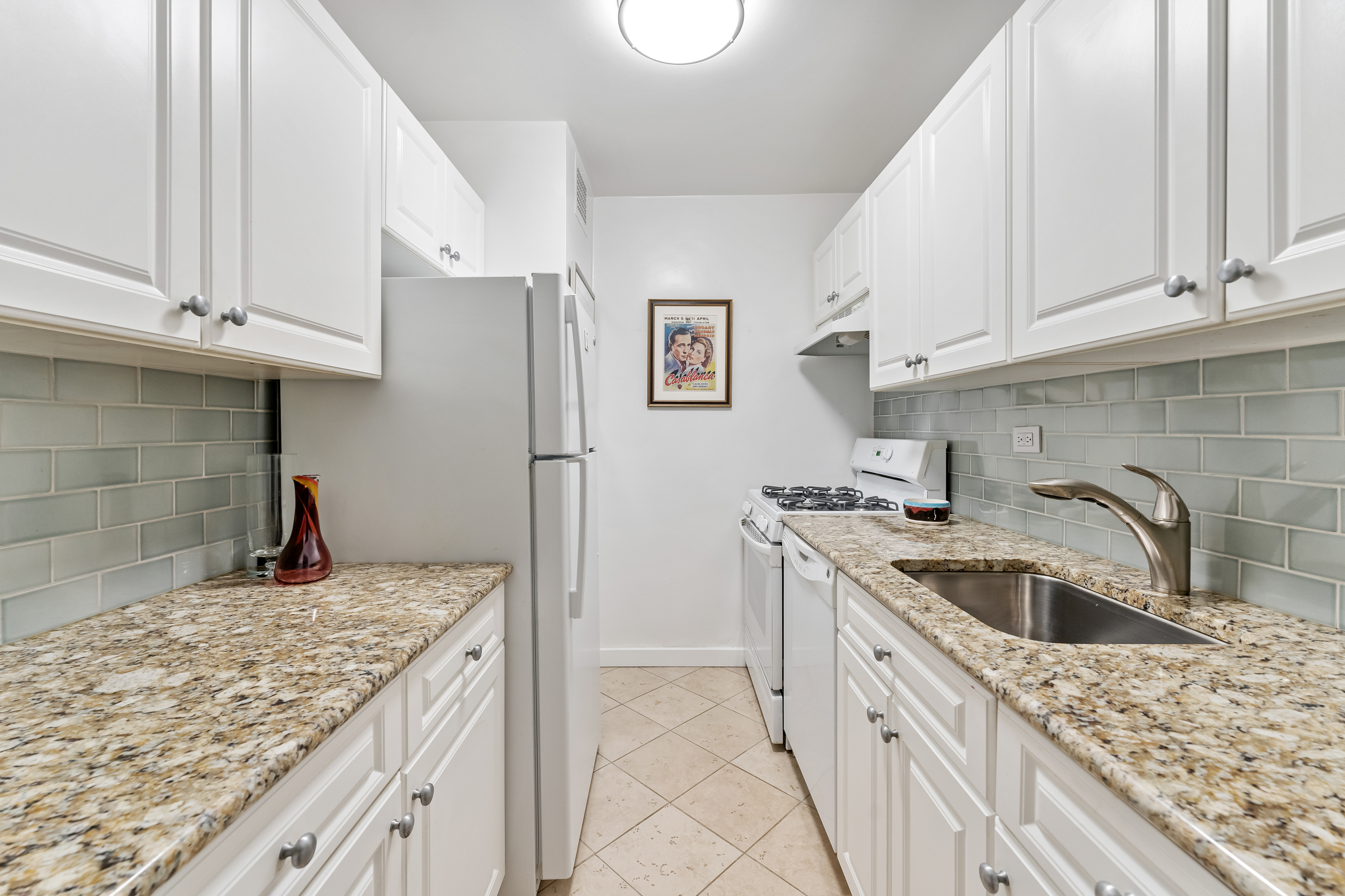 150 West End Avenue, Unit 10P Manhattan, NY 10023 - Photo 7 of 17 a kitchen with stainless steel appliances granite countertop a sink stove and cabinets