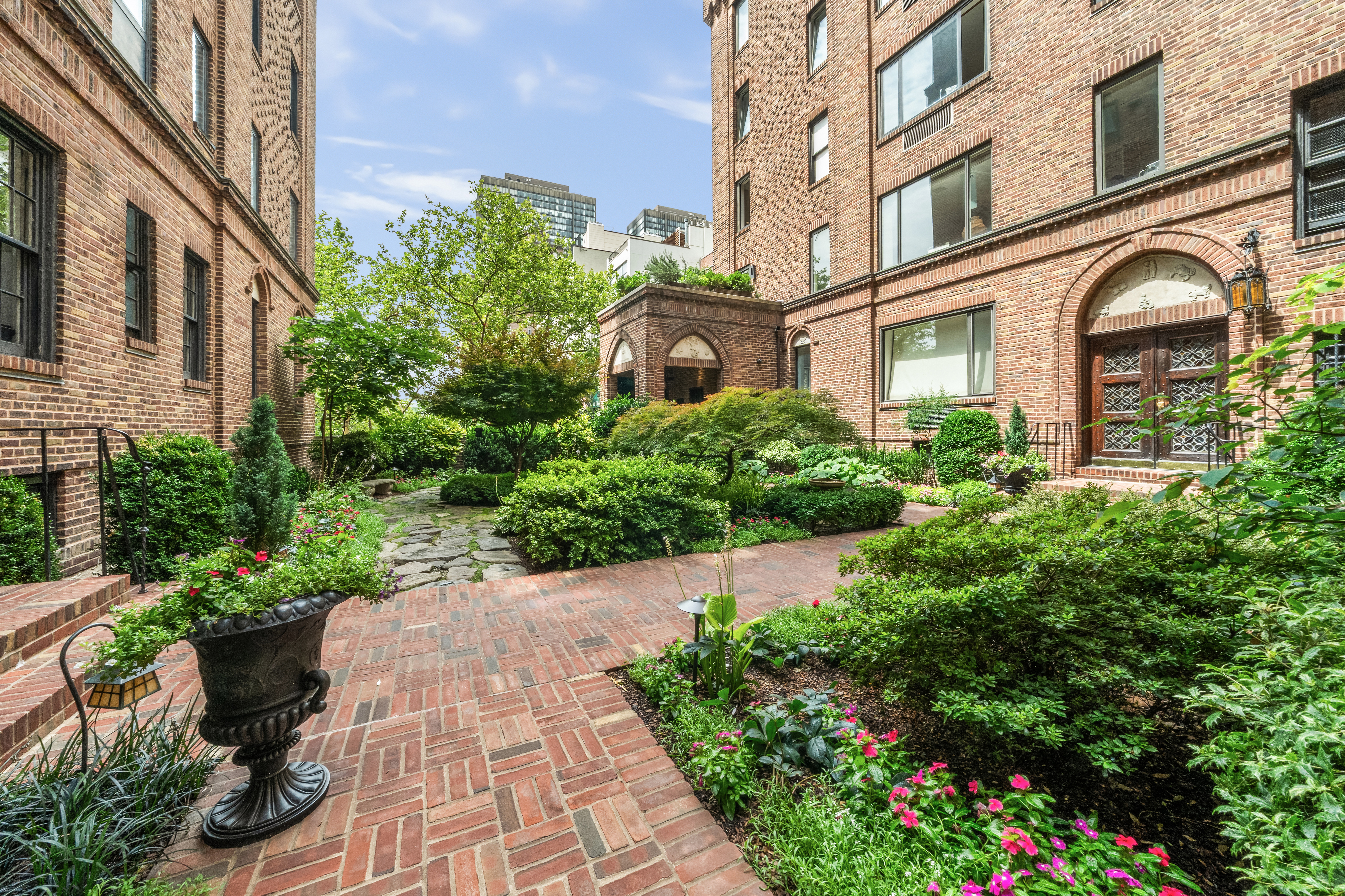 455 East 51st Street, Unit 2F Manhattan, NY 10022 - Photo 14 of 17 a front view of a multi story residential apartment building with yard and bench