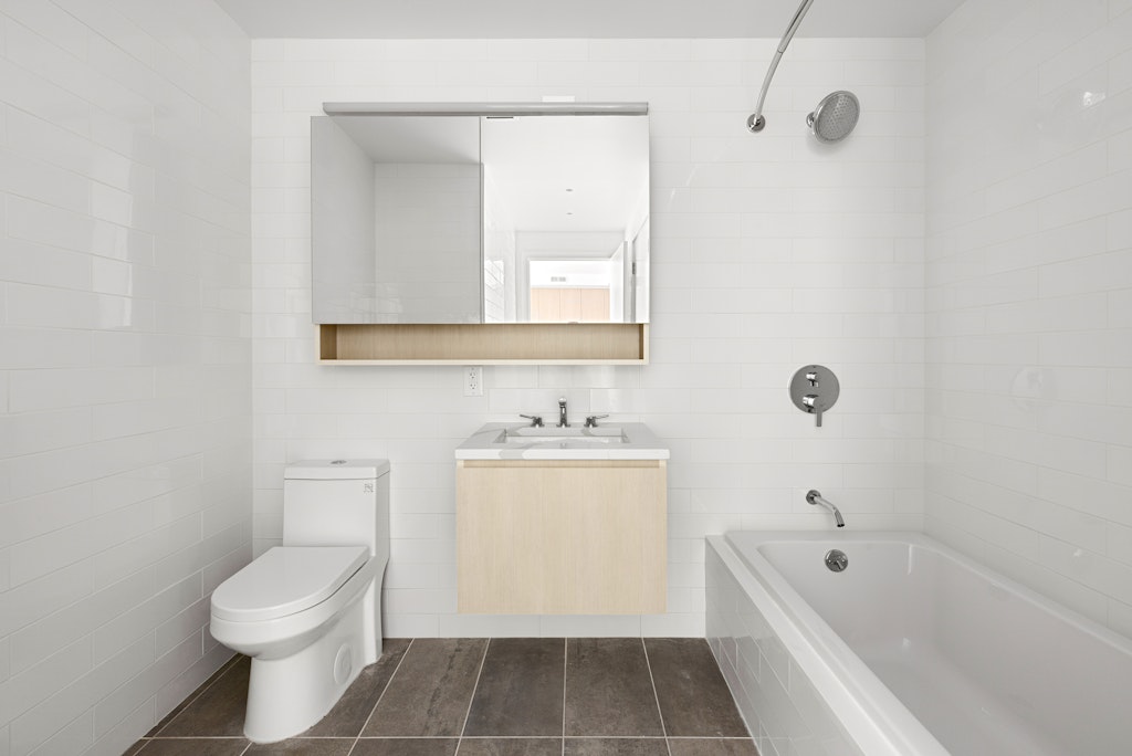 192 Spencer Street, Unit 4C Brooklyn, NY 11205 - Photo 4 of 7 a bathroom with a sink a toilet and shower