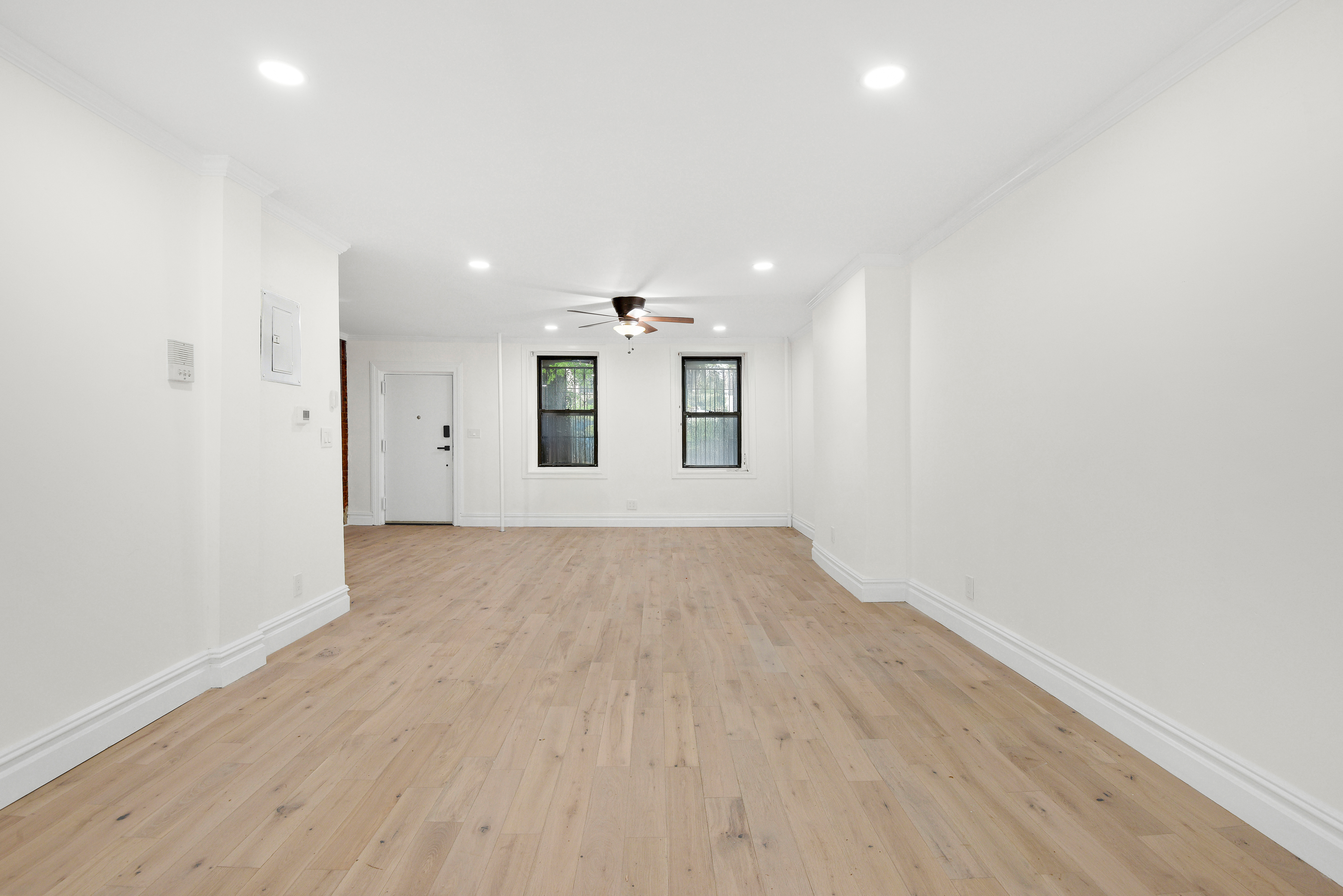 615 Willoughby Avenue, Unit 1 Brooklyn, NY 11206 - Photo 3 of 13 an empty room with wooden floor and windows
