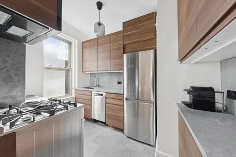 a kitchen with stainless steel appliances granite countertop a refrigerator and a stove