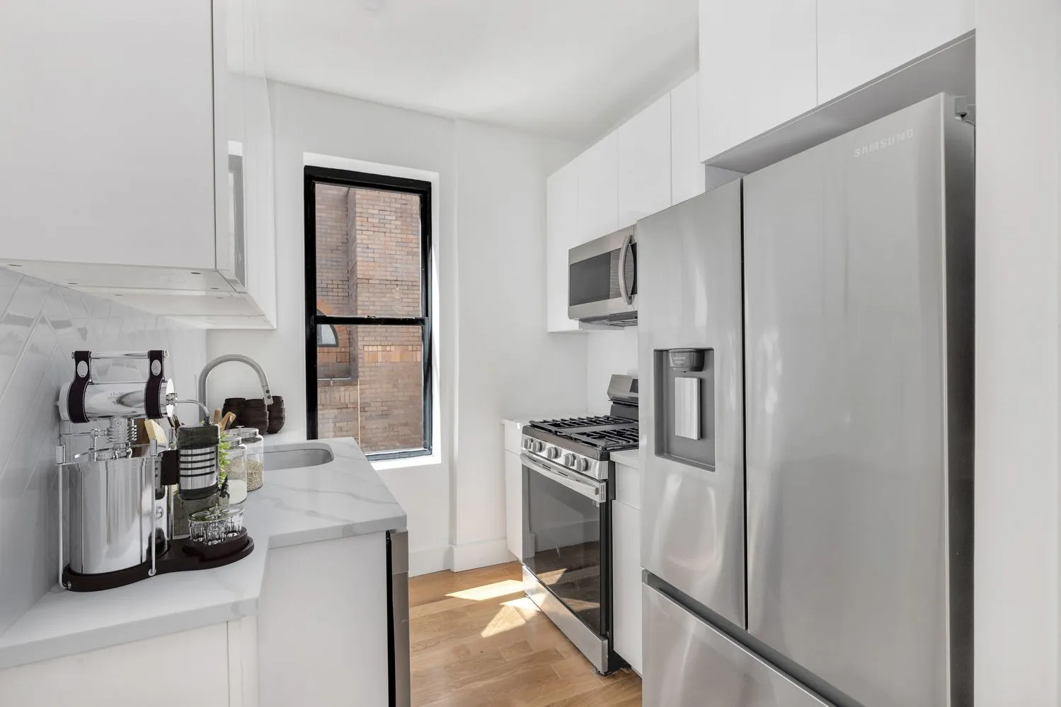 a kitchen with a refrigerator sink and white cabinets